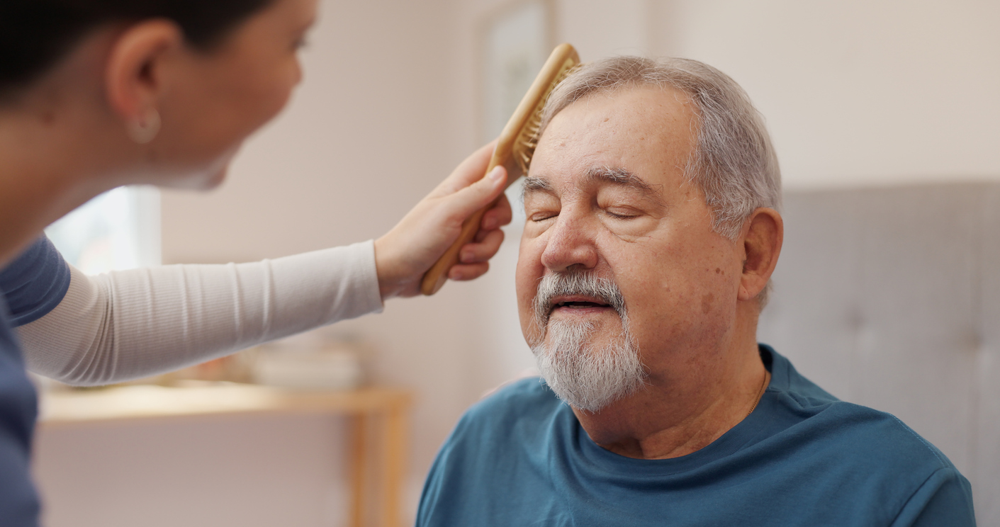 elderly man having hair brushed